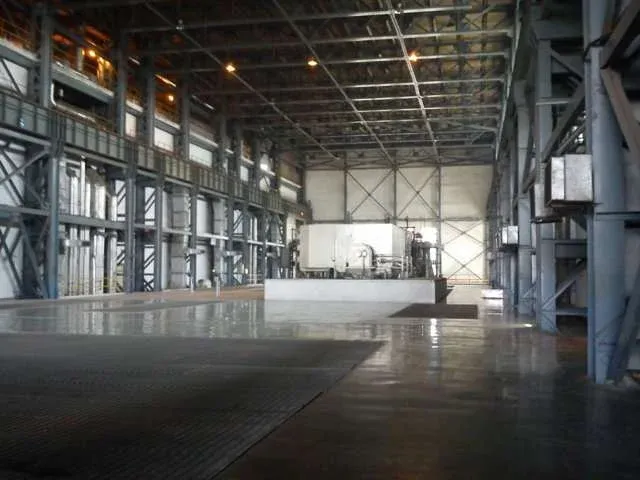 Industrial facility interior with structural steel framework and machinery setup