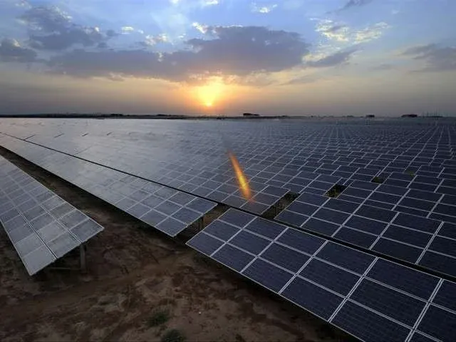 Renewable energy solar installation with wide panel arrays under evening sky