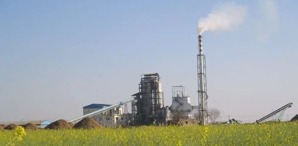 Industrial energy plant with chimney and processing equipment in rural area